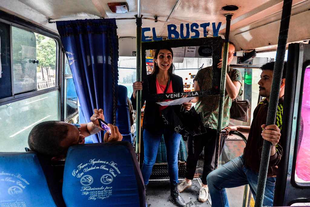 Maria Gabriela Fernandez (C) gives a presentation of the Bus TV news in Caracas, Venezuela, on June 6, 2017. A group of young Venezuelan reporters board buses to present the news, as part of a project to keep people informed in the face of what the opposi