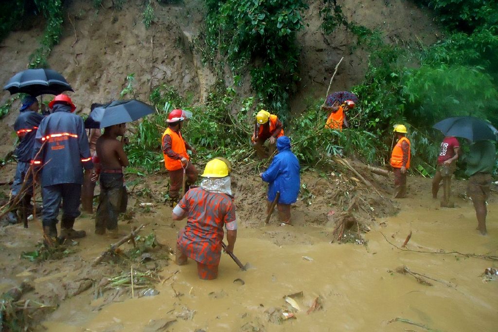 Bangladeshi fire fighters search for bodies after a landslide in Bandarban on June 13, 2017. Heavy monsoon rains have killed at least 46 people in southeast Bangladesh, most of them buried under landslides, authorities said on June 13. / AFP.