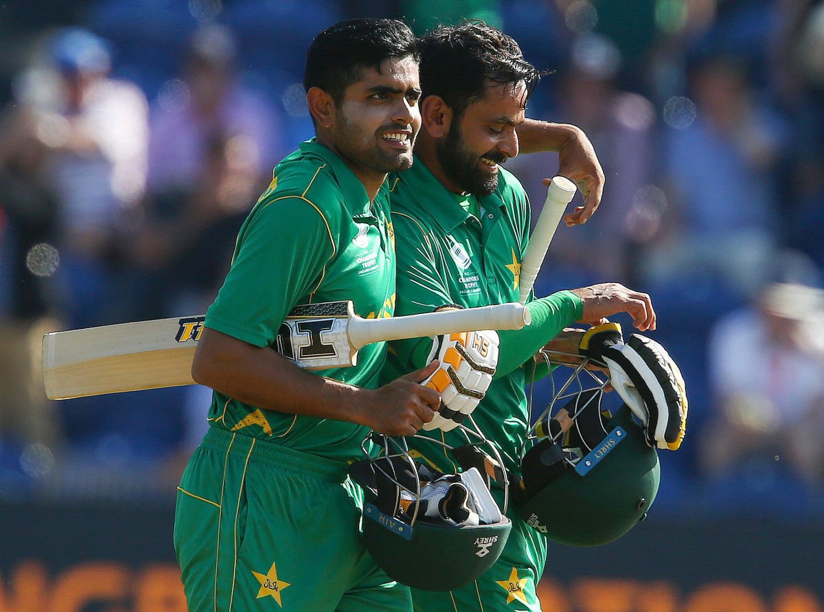 Pakistan's Mohammad Hafeez (R) and Pakistan's Babar Azam walks back to the pavilion after Pakistan won the ICC Champions Trophy semi-final cricket match between England and Pakistan in Cardiff on June 14, 2017. Set just 212 for victory, Pakistan finished 