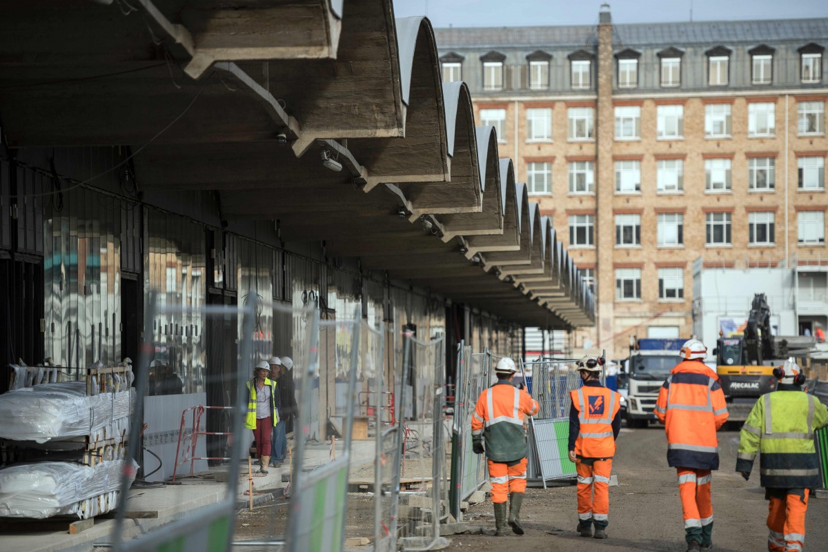 This file photo taken on October 18, 2016 shows workers walking through the construction site of the world-biggest start-up incubator Station F, formerly known as the Halle Freyssinet in Paris (AFP / Lionel Bonav) 