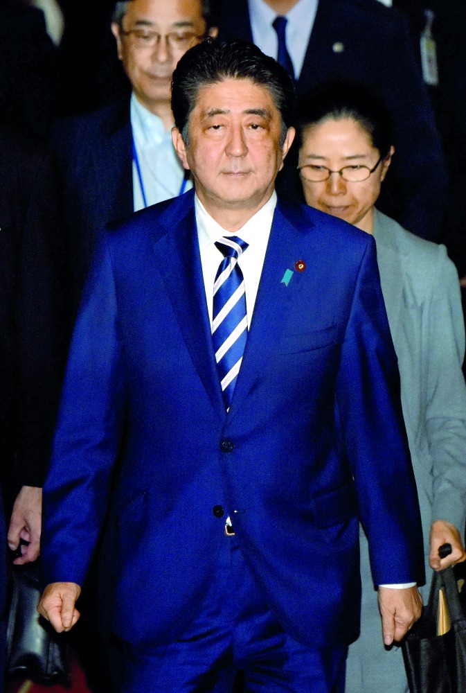 Japanese Prime Minister Shinzo Abe (C) heads for the budget committee of the upper house of parliament in Tokyo on June 16, 2017. Abe was under mounting pressure over allegations that he used his influence to help a friend in a business deal after two off