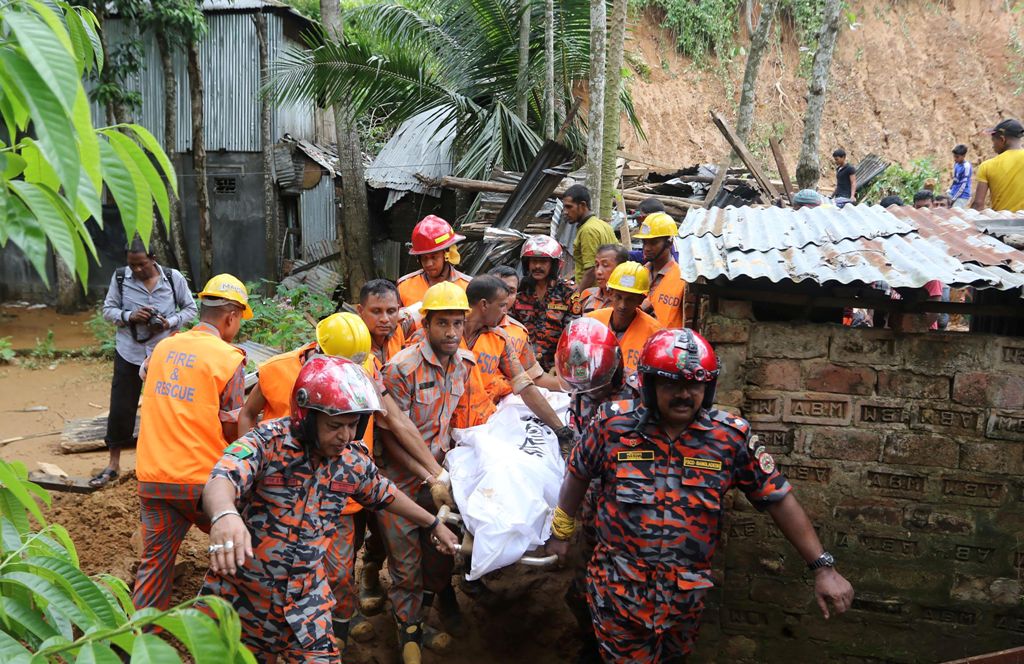 Bangladeshi firefighters carry a dead body at the site of a landslide in Rangamati on June 15, 2017. AFP