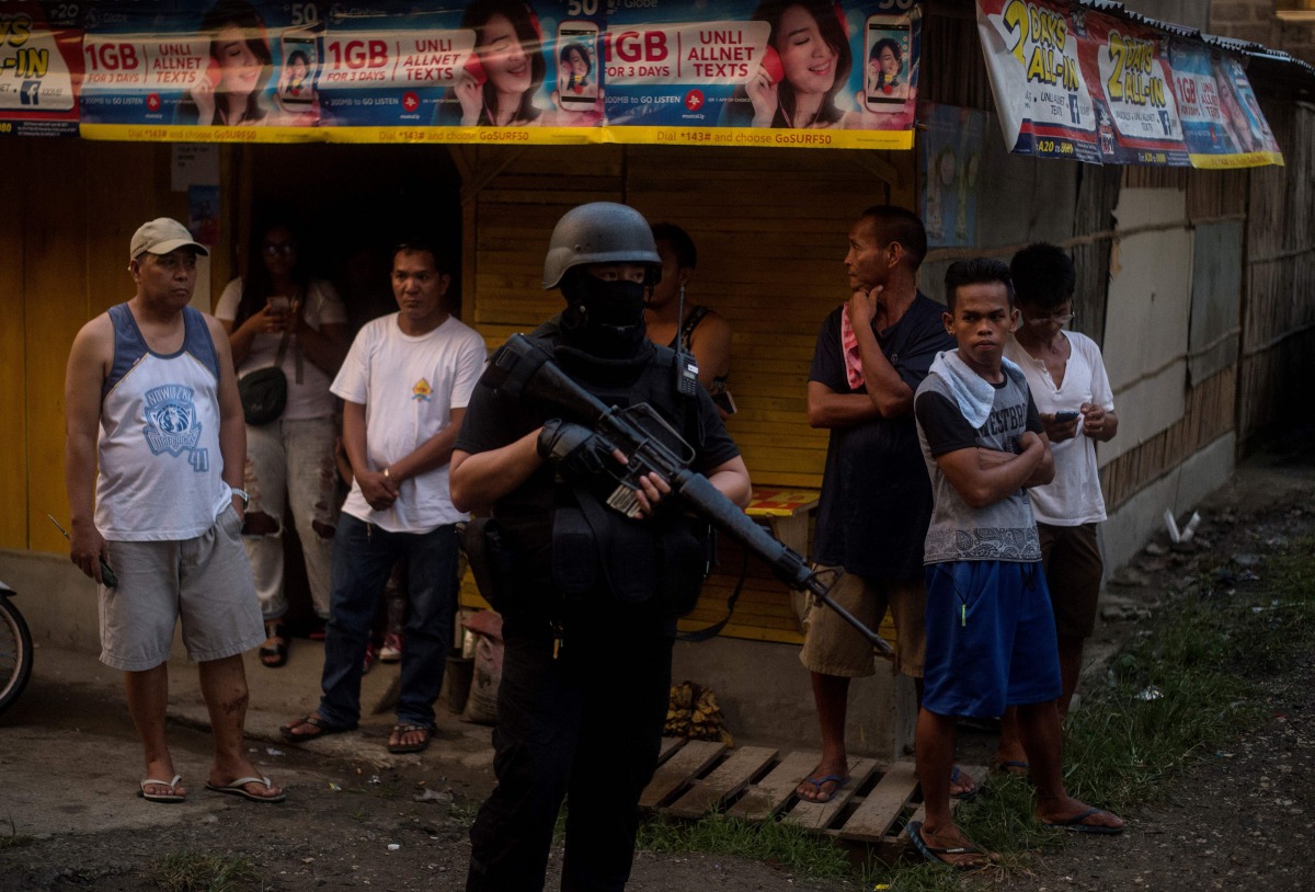 Philippine members of Special Weapons and Tactics (SWAT) patrol a neighborhood where evacuees from Marawi City are temporarily living in Iligan City on June 16, 2017. AFP / NOEL CELIS