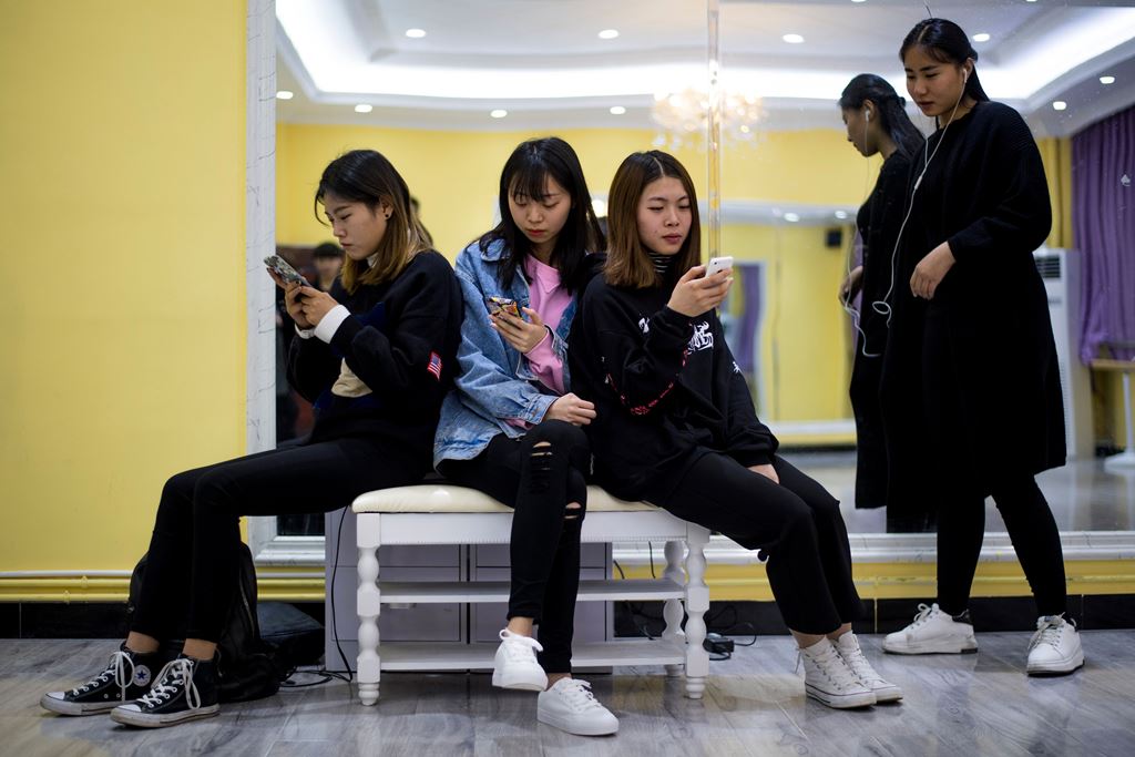 This picture taken on March 14, 2017 shows students looking at their smartphones during a class at the Yiwu Industrial & Commercial College in Yiwu, east China's Zhejiang Province. AFP / Johannes EISELE 
