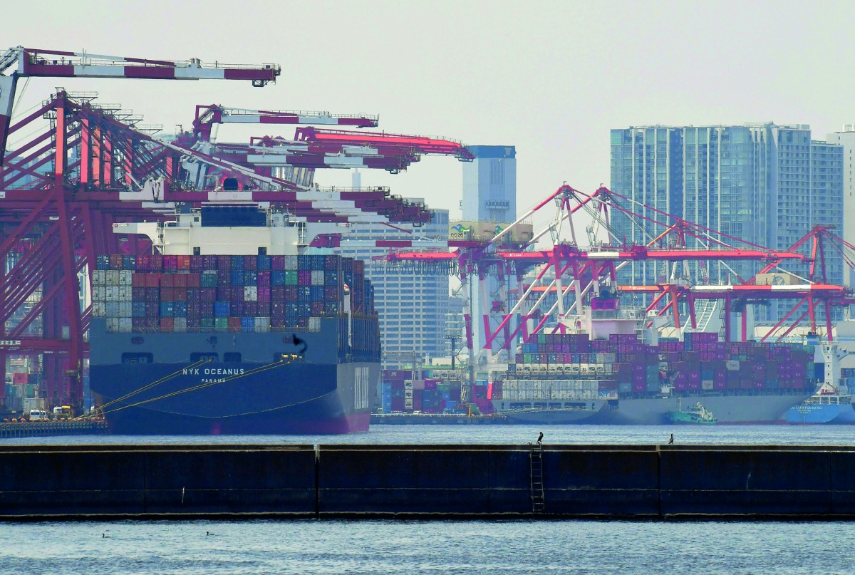 Container ships anchor at a pier in Tokyo port yesterday. Japan logged a surprise deficit of $1.8bn, despite market expectations for a surplus.