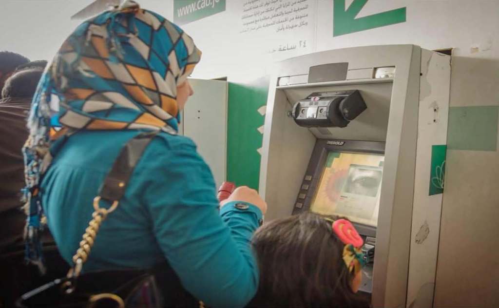 A woman withdrawing cash from an ATM machine.