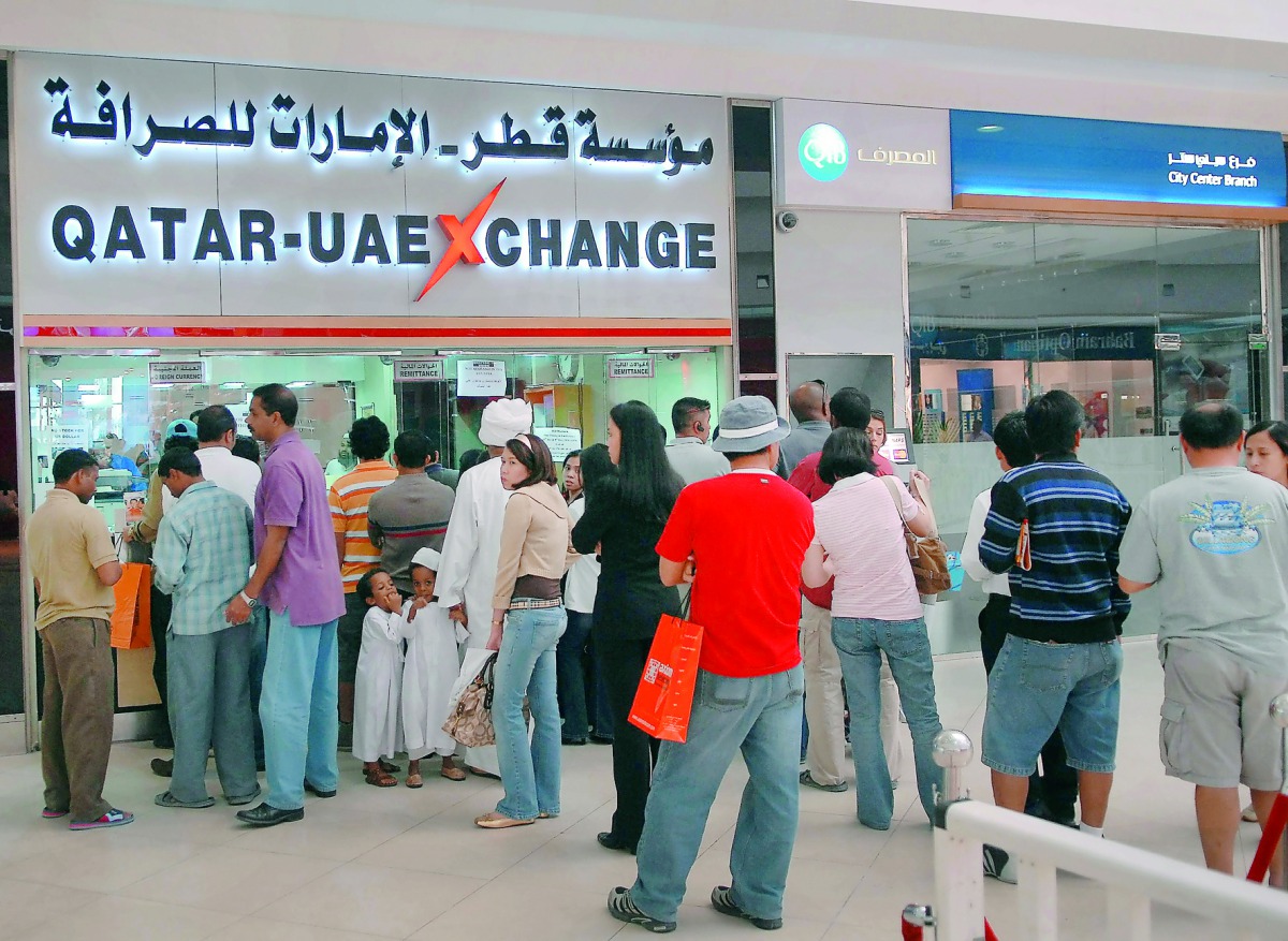 Expats standing in queue at an exchange house to send money to relatives back home.