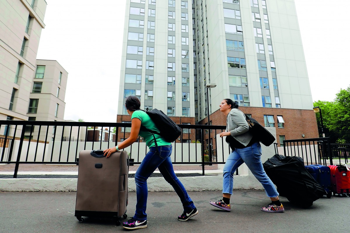 People with suitcases leave Taplow Tower residential block on the Chalcots Estate in north London, yesterday, as residents evacuate because of fire safety concerns.  