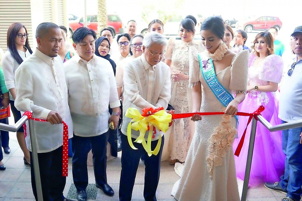 Philippine Ambassador Alan L Timbayan (second right) cutting the ribbon while Labour Attaché David Des Dicang (second left), UFOQ Chairman Ressie Fos (left) and Mutyang Pilipinas Tourism International 2016 Justine Mae San Jose look on at the opening of th