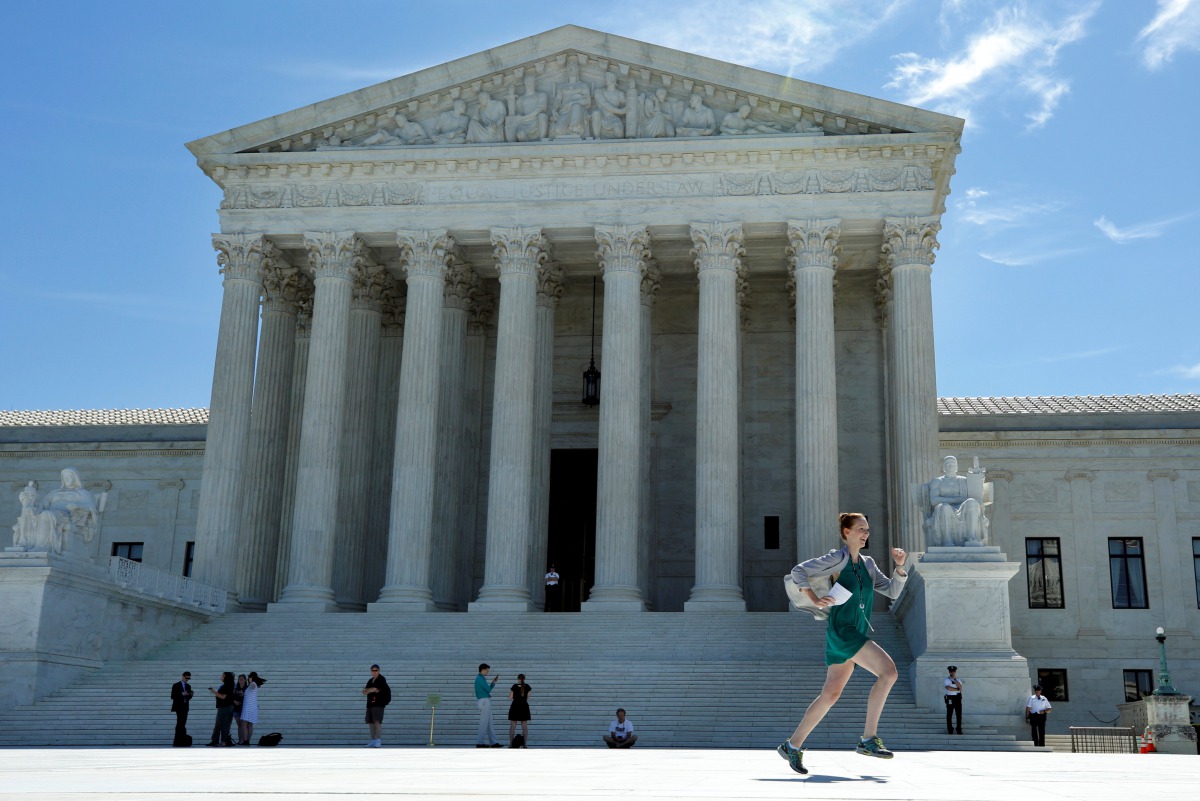 A news assistant runs out after the US Supreme Court granted parts of the Trump administration's emergency request to put his travel ban into effect immediately while the legal battle continues, in Washington, U.S., June 26, 2017. (REUTERS/Yuri Gripas)
