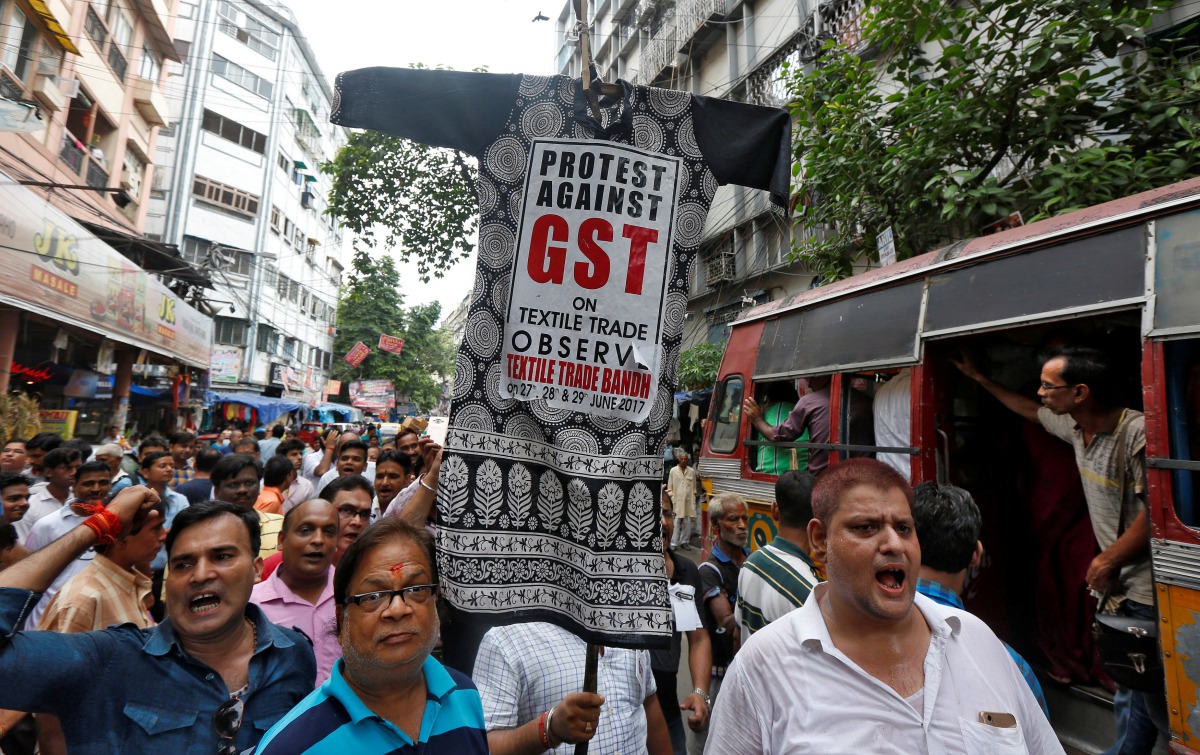 Cloth merchants and workers shout slogans as they carry an effigy depicting Goods and Services Tax (GST) in a market area during a protest rally against implementation of GST on textiles in Kolkata, India, June 28, 2017. (REUTERS/Rupak De Chowdhuri)