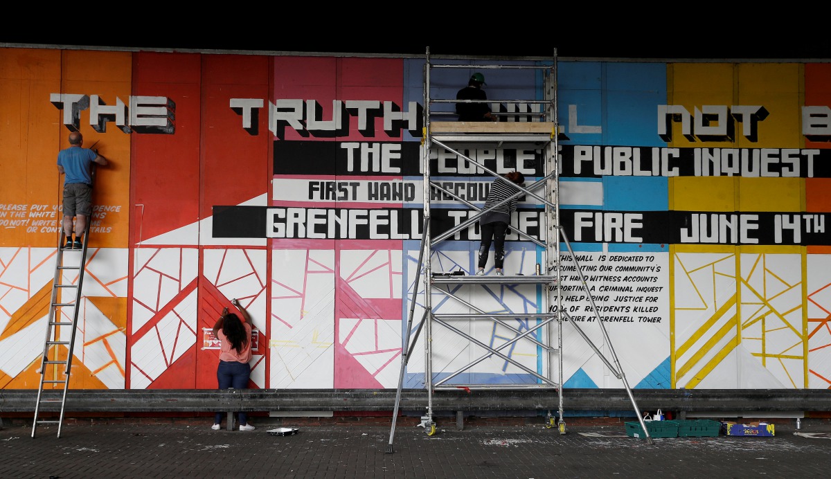 Volunteers work on a mural, on which people will be encouraged to write accounts of their experiences in connection with the Grenfell Tower fire, in north Kensington London, Britain, June 25, 2017. Reuters/Peter Nicholls