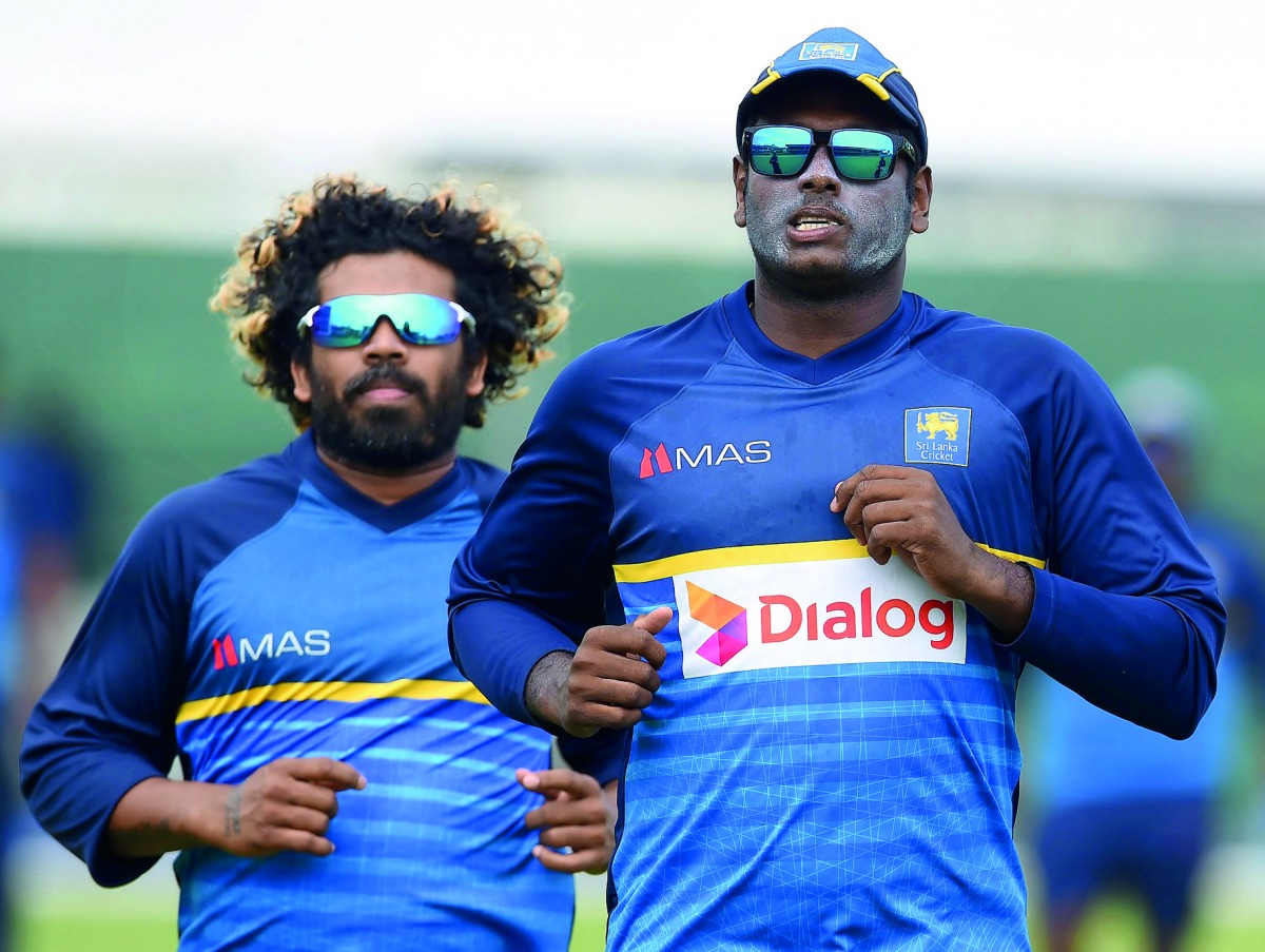Sri Lankan cricket captain Angelo Mathews (right) warms up with team-mate Lasith Malinga during a practice session at Galle International Cricket Stadium in Galle yesterday.