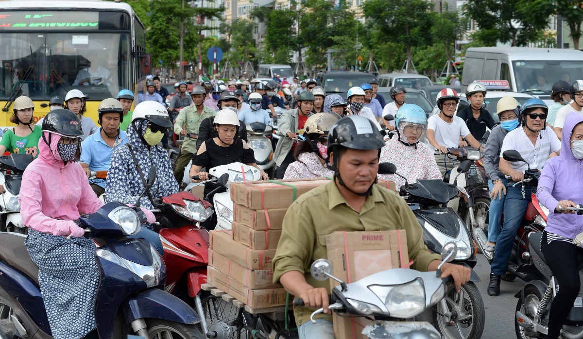 Motorcyclists cross an intersection in downtown Hanoi on July 4, 2017. Officials in Vietnam's traffic-clogged capital Hanoi vowed on July 4 to banish motorbikes by 2030 to ease environment and congestions woes, a decision that swiftly divided a city where