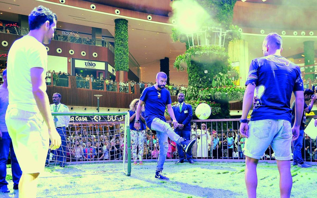 Barcelona's Gerard  Pique (centre) shows off his skills during an interaction with fans while his team-mates Sergio Busquets and Jordi Alba look on at Mall of Qatar yesterday. Picture: Baher Amin / The Peninsula