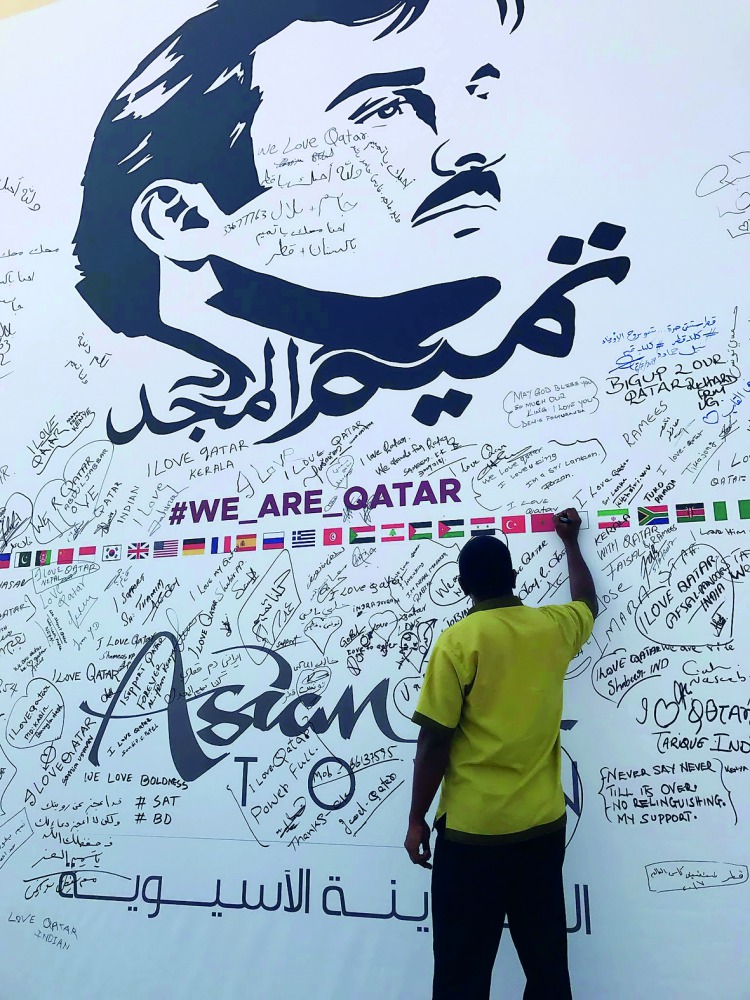 A labourer signing the painting at Asian Town.