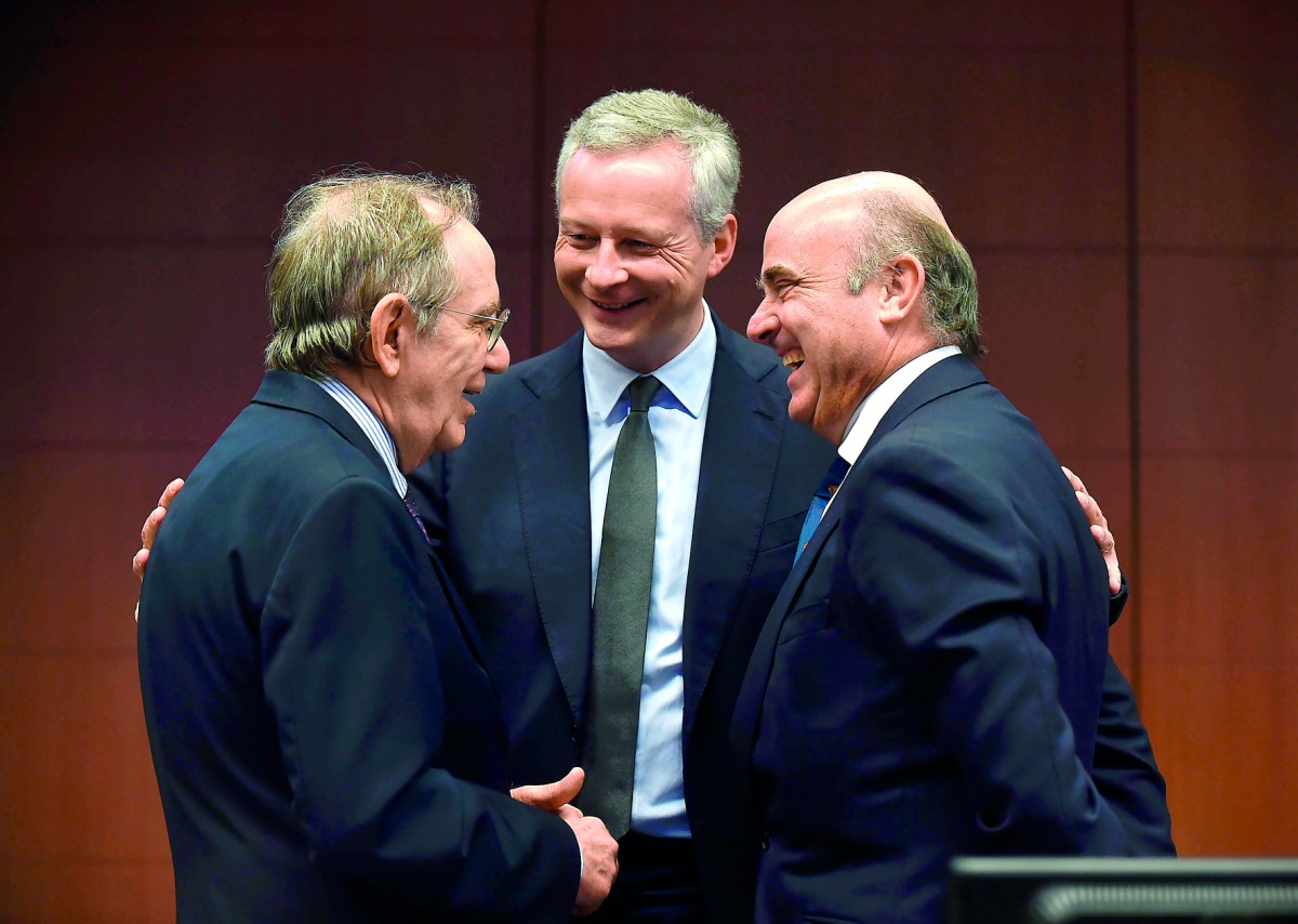 French Economy, Finance and Trade Minister Bruno Le Maire (centre) speaks with Italian Minister of Economy and Finance Pier Carlo Padoan (left) and Spain's Economy Minister Luis de Guindos, during a Eurogroup meeting at the European Union (EU) headquarter