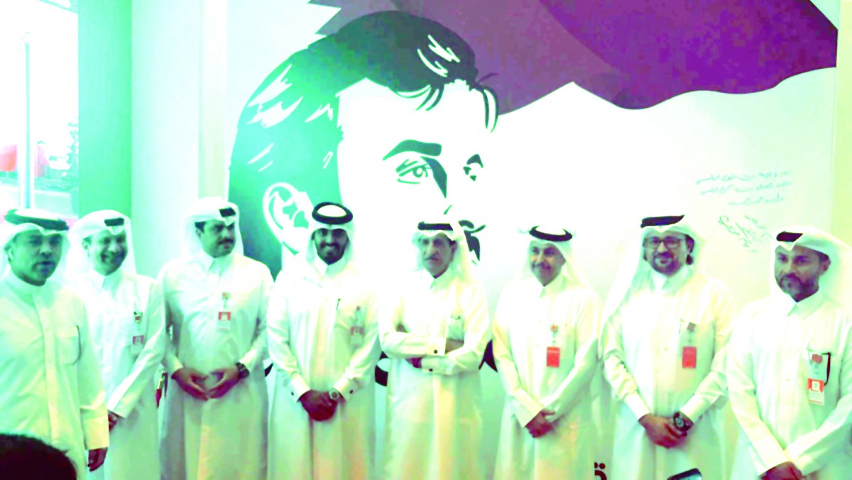 Ooredoo officials, pose before the image of the Emir H H Sheikh Tamim bin Hamad Al Thani, expressing solidarity with Qatar. 