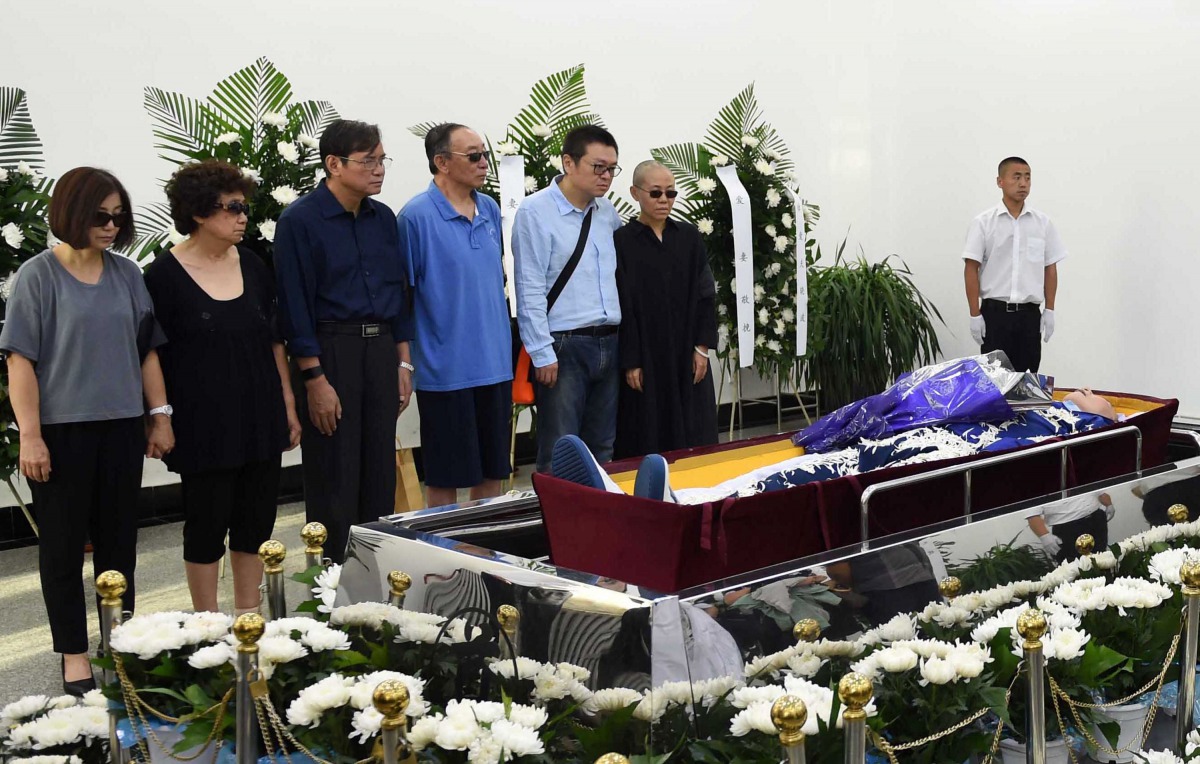 This handout photo provided by the Shenyang Municipal Information Office shows late Nobel laureate Liu Xiaobo's wife Liu Xia (R-in black) and family members standing next to Liu Xiaobo's body at a funeral parlour in the Chinese city of Shenyang, Liaoning 
