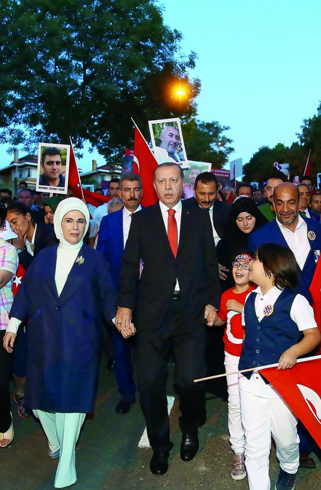 Turkey's President Recep Tayyip Erdogan (centre) and his wife Emine Erdogan walk to a ceremony site on Martyrs Bridge (Bosphorus Bridge) in Istanbul, yesterday. Turkey is marking one year of the defeated coup. 
