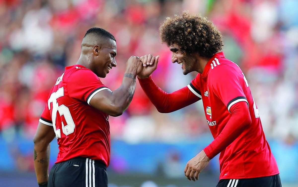 Manchester United’s Marouane Fellaini celebrates scoring a goal with Antonio Valencia.