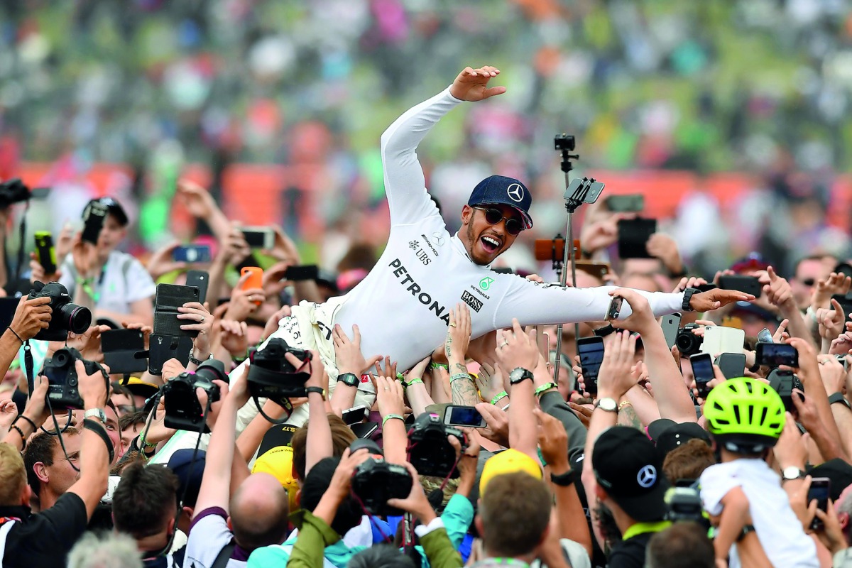 Mercedes’ British driver Lewis Hamilton celebrates with fans after he won the British Formula One Grand Prix at the Silverstone motor racing circuit in Silverstone, central England.