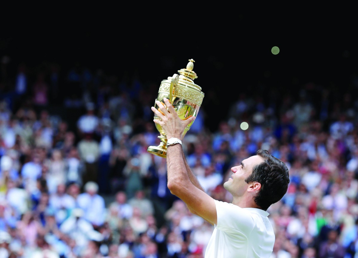 Switzerland’s Roger Federer poses with the trophy as he celebrates winning the men's singles final of the 2017 Wimbledon Championships against Croatia’s Marin Cilic at the All England Lawn Tennis Club in Wimbledon, southwest London yesterday. Federer won 