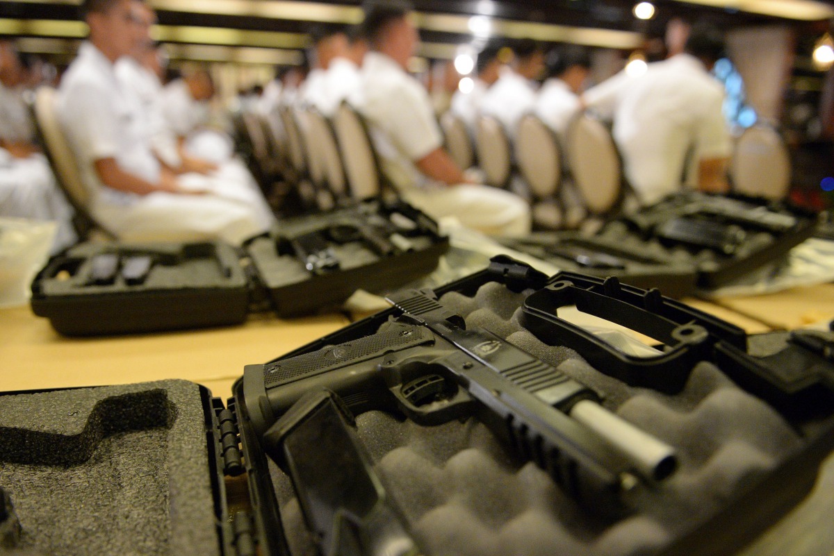 Philippine soldiers are seen past .45 caliber handguns ahead of a handover of some 3,000 units of the weapons to the military, at Malacanang Palace in Manila on July 18, 2017. President Duterte announced plans July 18 to extend martial law in the southern