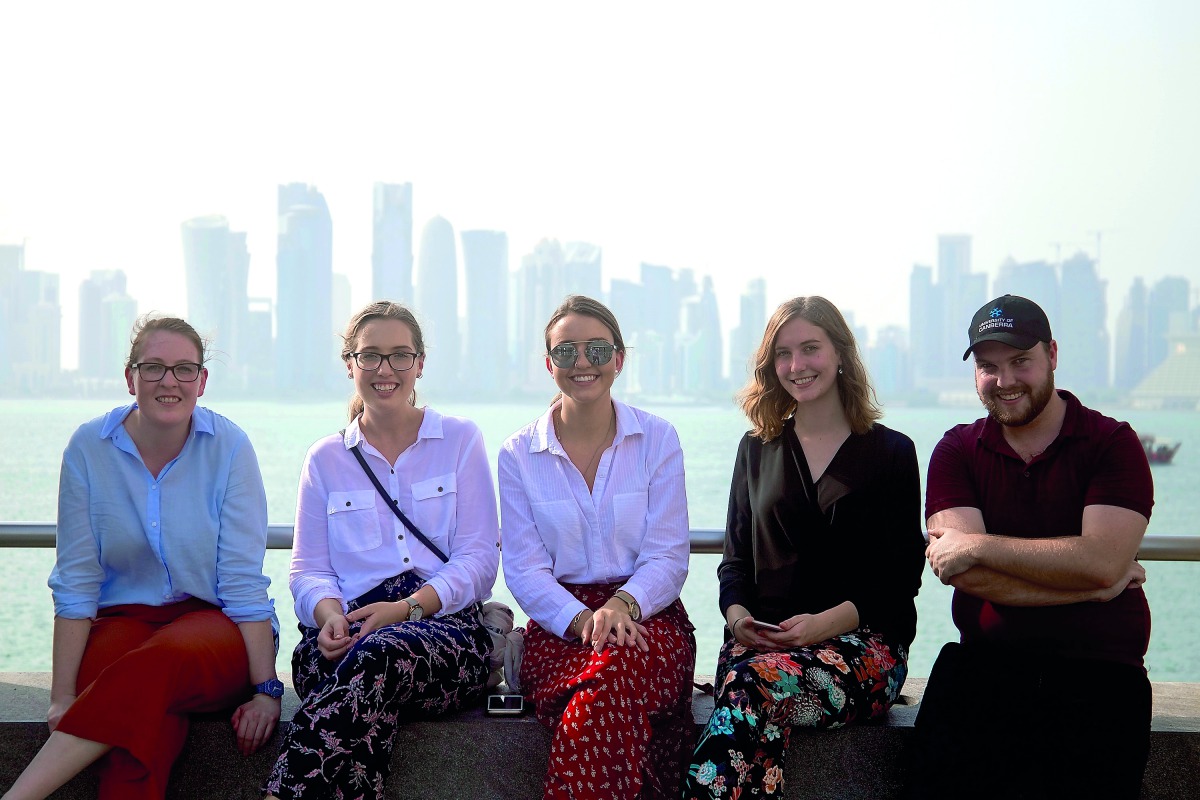 Student journalists Laura Clements, Claire Grinsell-Jones, Lucy Harrington, Alyssia Tennant, and Tom Storey pose with the Doha skyline as the backdrop. 