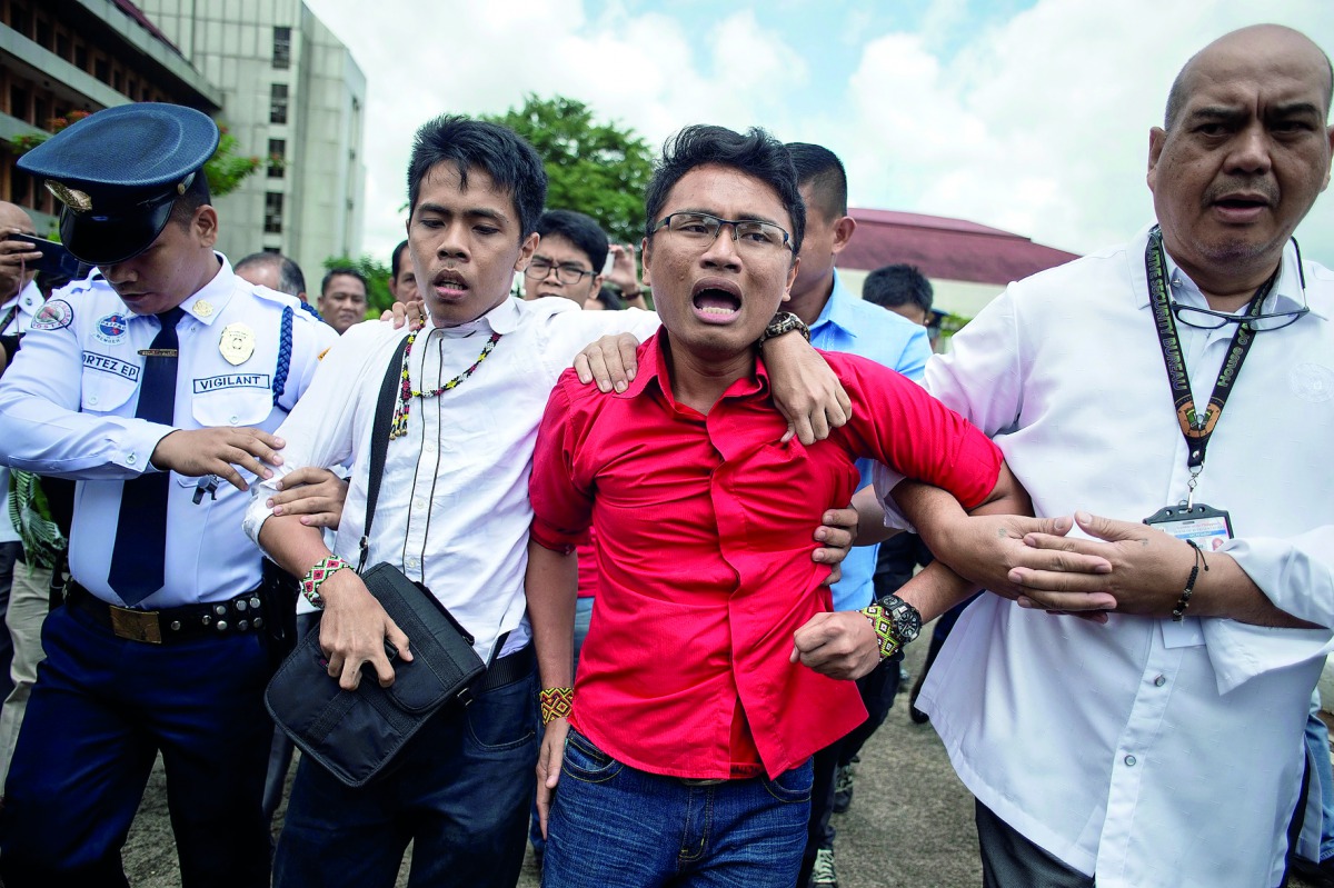 Activists are escorted from the Plenary Hall of the House of Representatives.