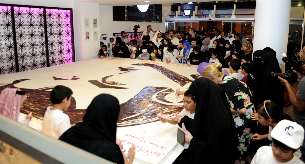 People writing on the cake with icing. (Photo: Salim Matramkot)