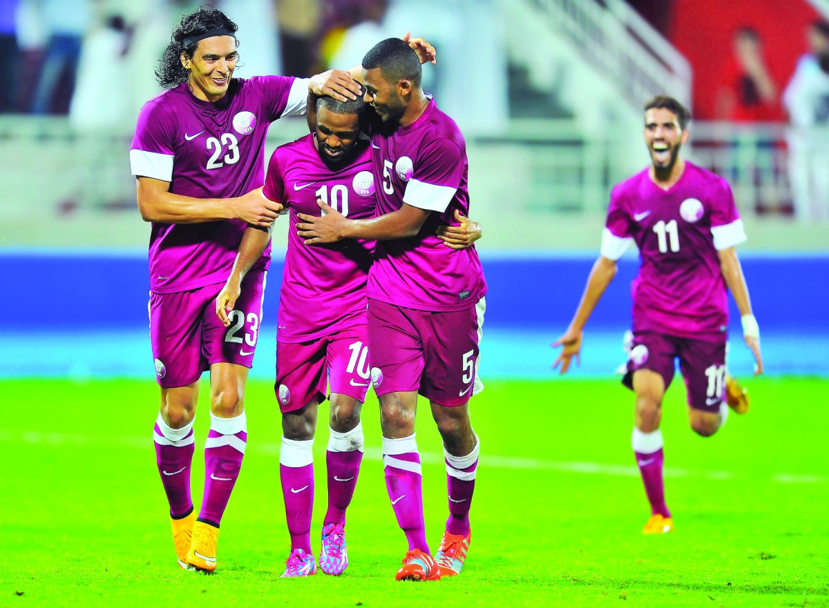 Qatar’s Khalfan Ibrahim (centre) celebrates with team-mates after scoring a goal during a friendly against Australia at the Lekhwiya Stadium in Doha, in this file photo.