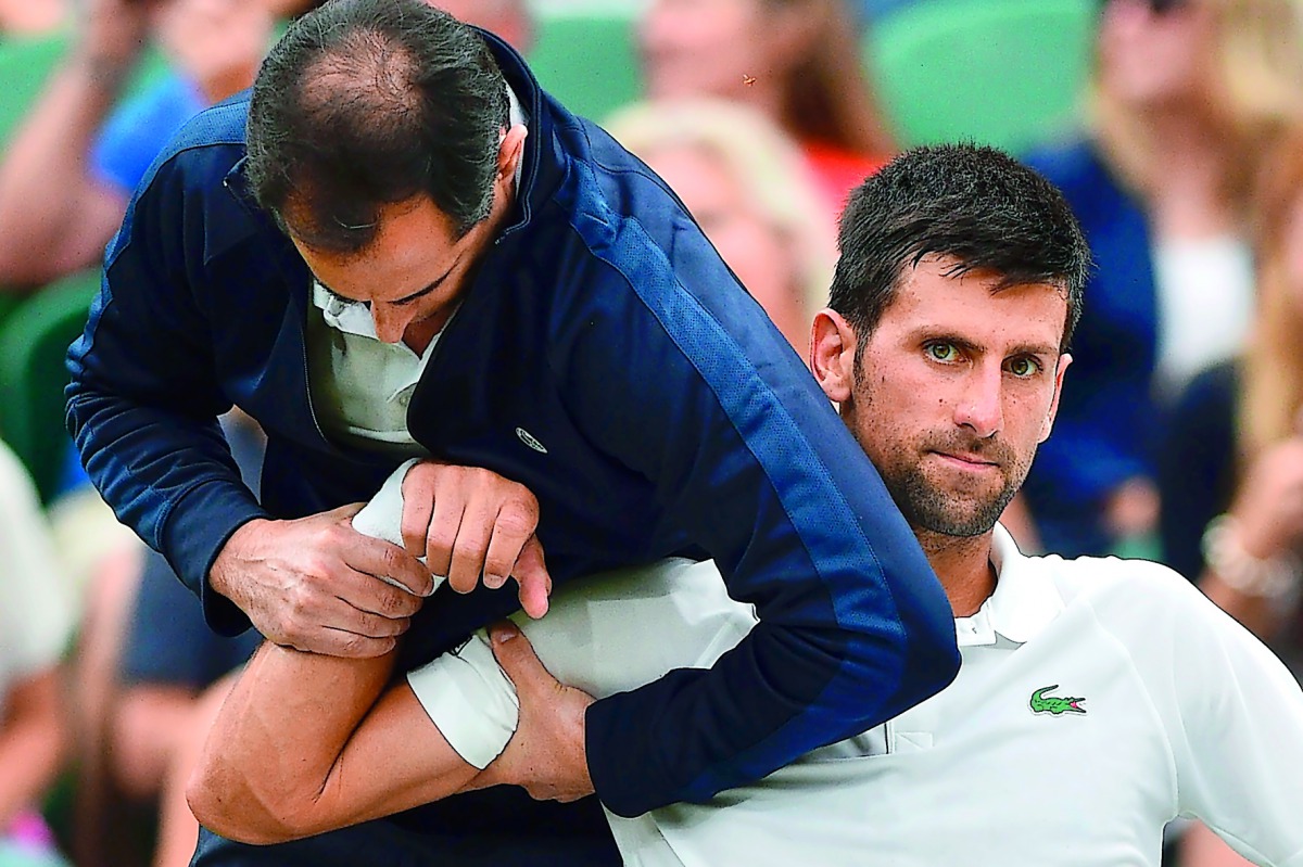 Novak Djokovic of Serbia gets some medical attention on court in a break between games against France’s Adrian Mannarino at the 2017 Wimbledon Championships in this July 11, 2017 file photo. 