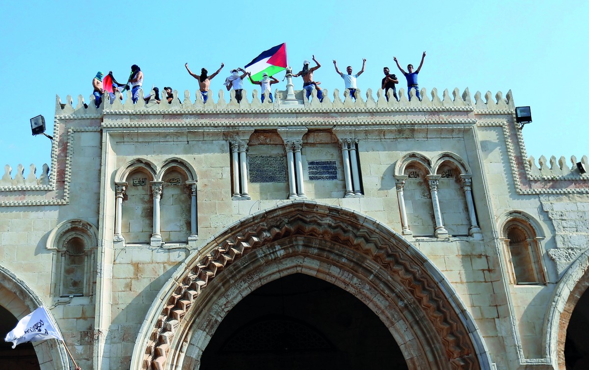 Palestinians gather inside the compound of Al Aqsa Mosque, after Israel removed all security measures it had installed at the compound, in Jerusalem’s Old City, yesterday.