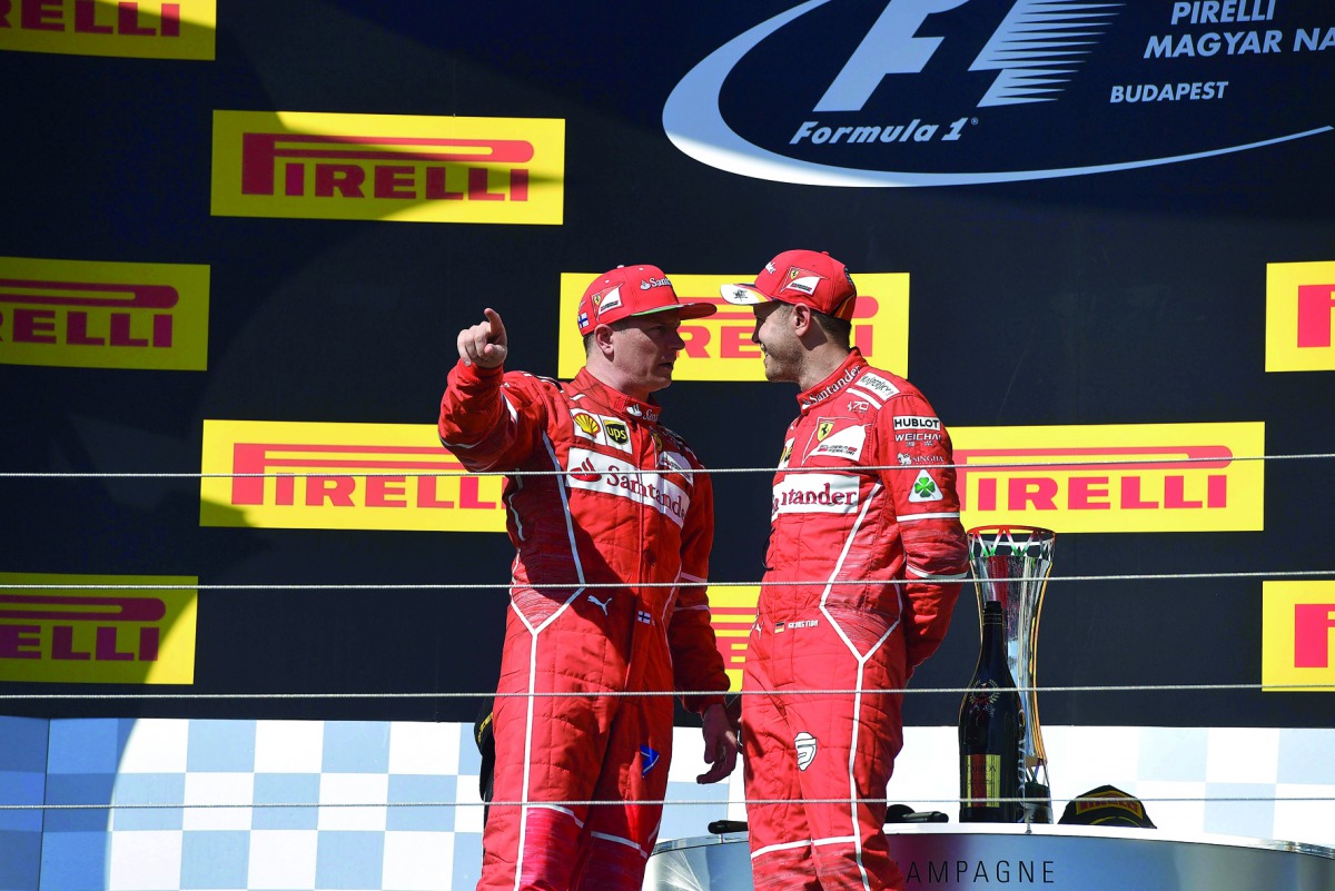 Second-placed Ferrari’s Finnish driver Kimi Raikkonen (left) and winner Ferrari’s German driver Sebastian Vettel stand on the podium after the Formula One Hungarian Grand Prix at the Hungaroring Racing Circuit in Budapest on Sunday. 