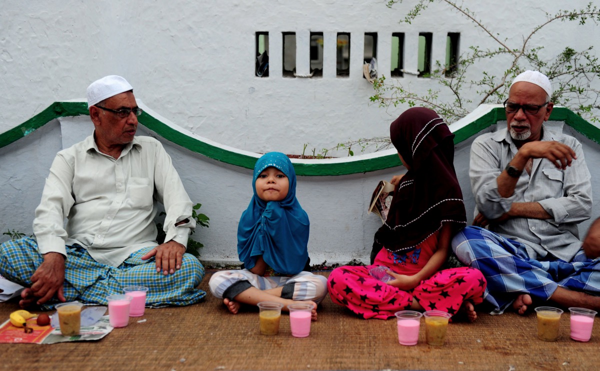 File photo of a young Indian child sitting with fellow Muslims as they prepare to break the fast with the Iftar meal during  Ramadan at The Wallajah Big Mosque in Chennai on July 1, 2016 (Reuters) 