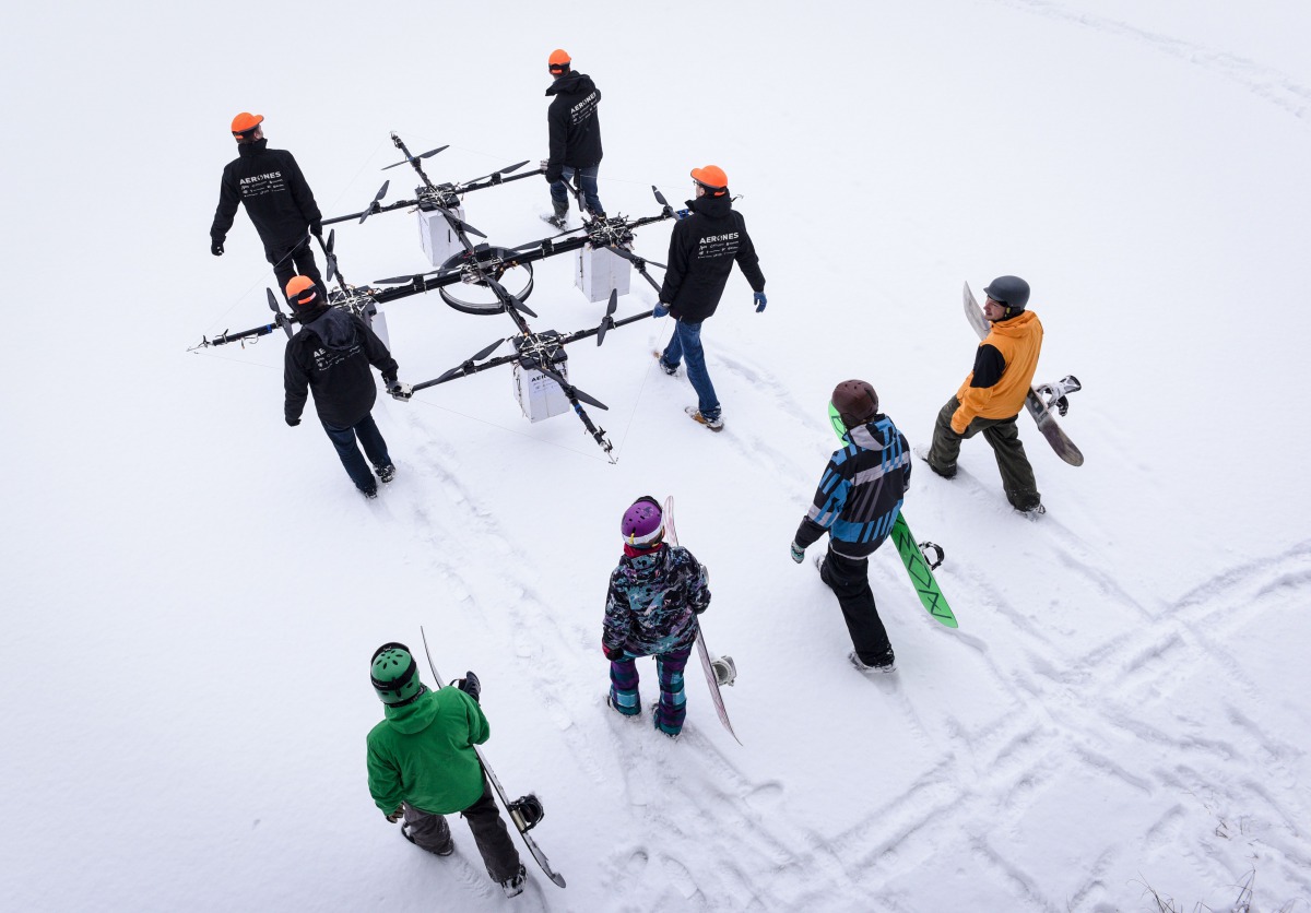 This January 14, 2017 photo shows snowboarders walking as sixteen propeller drone is carried to Niniera lake surface near Cesis, Latvia (AFP / Ilmars Znotins) 