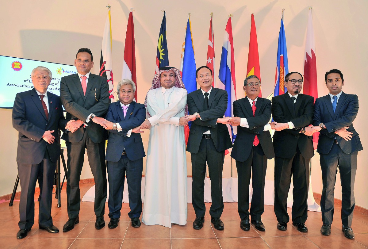 Thailand Ambassador and ACD Chairman Soonthorn Chaiyindeepum (fourth right), Ibrahim Fakhroo, Director of Protocol at the Ministry of Foreign Affairs (fourth left) and other Asean ambassadors in the traditional Asean handshake during celebrations of the b