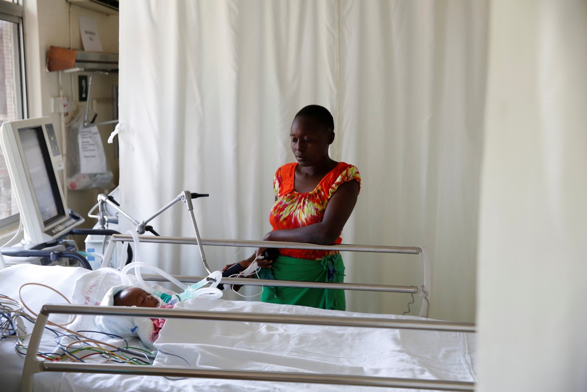 Lenzer, mother of six month-old Samantha Pendo, stands next to her bed as the girl remains in critical condition in the Intensive Care Unit of Aga Khan Hospital in Kisumu, Kenya August 14, 2017. Reuters/Baz Ratner