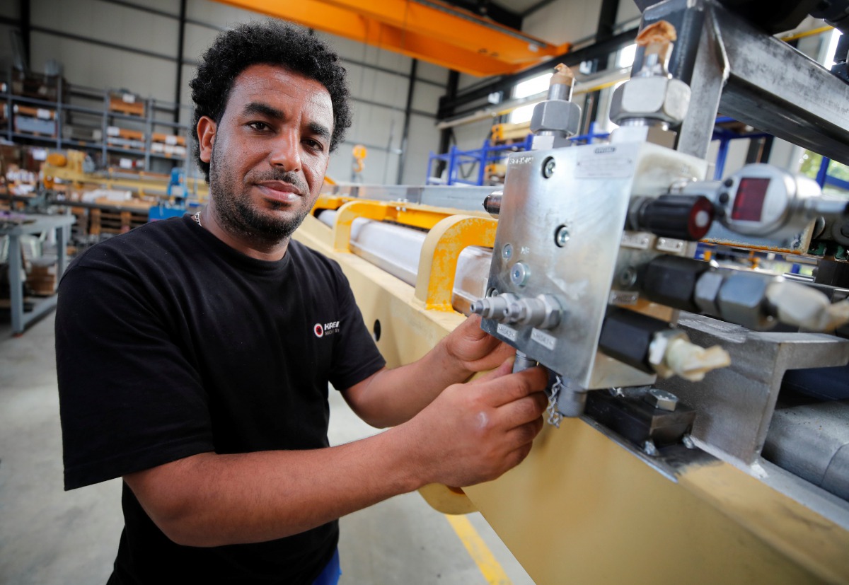 Merhawi Tesfay, an immigrant from Eritrea poses during a Reuters interview at German plant engineering firm Kremer Machine Systems where he found a job as electrician and plant manufacturer in Gescher near Muenster, Germany, August 4, 2017. Reuters/Wolfga