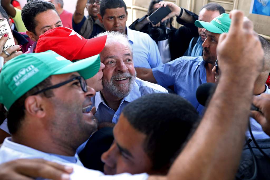 Former Brazilian President Luiz Inacio Lula da Silva (C) poses for pictures as he meets farmers during his 