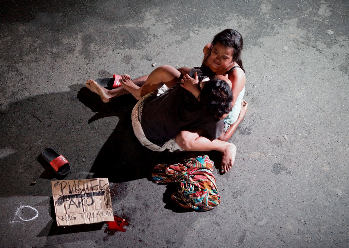 A Filippina called Jennelyn Olaires, 26, cradles the body of her partner who was killed on a street by a vigilante group according to police in a spate of drug related killings in Pasay city, Metro Manila . (Reuters / Czar Dancel) 