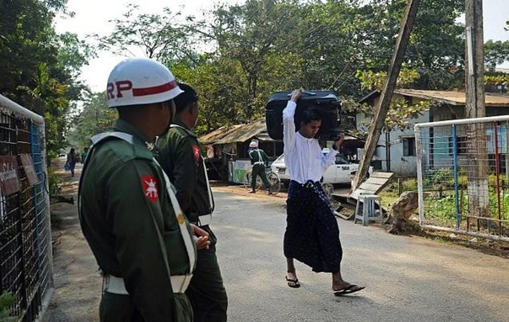 A former Myanmar child soldier (R) carries his belongings as he walks out from a military compound in Yangon after a ceremony discharging a group of children in 2014. / AFP.