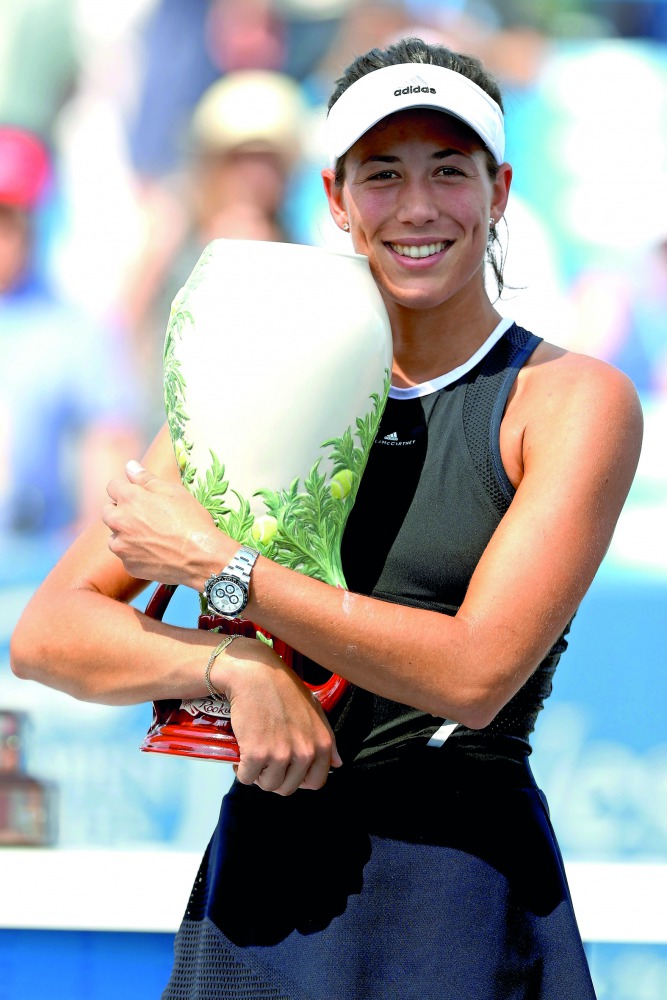 Garbine Muguruza of Spain poses with the winner’s trophy after defeating Simona Halep of Romania during the women’s final of Cincinnati Open on Sunday.