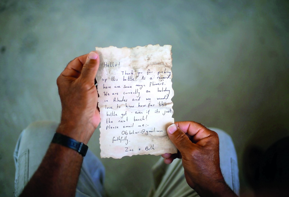 Soltan displays a message that was written by Bethany Wright and her boyfriend Zac Marriner, after he found it in a bottle off a Gaza beach.