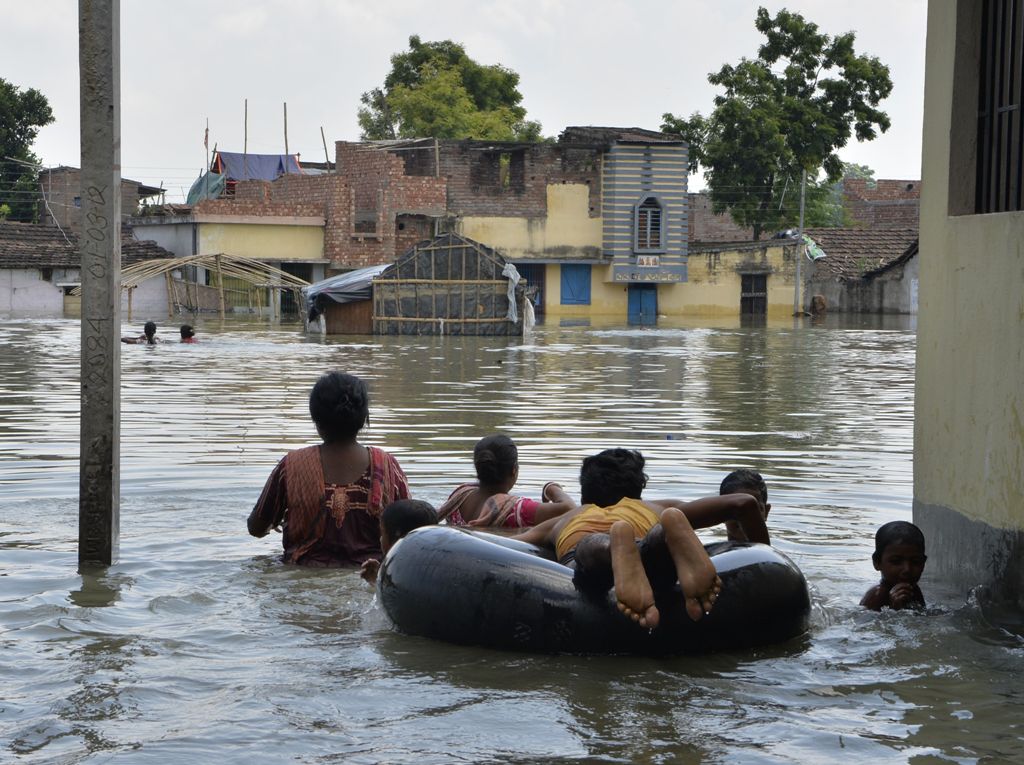 Indian residents wade through flood waters in Malda in the Indian state of West Bengal on August 24, 2017.  AFP / DIPTENDU DUTTA
