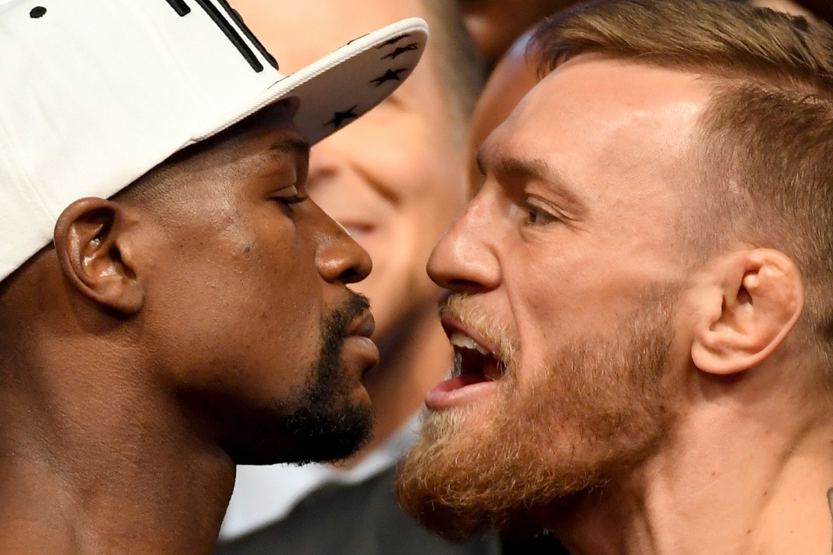 Boxer Floyd Mayweather Jr. (L) and UFC lightweight champion Conor McGregor face off during their official weigh-in at T-Mobile Arena on August 25, 2017 in Las Vegas, Nevada. (Ethan Miller/Getty Images/AFP)