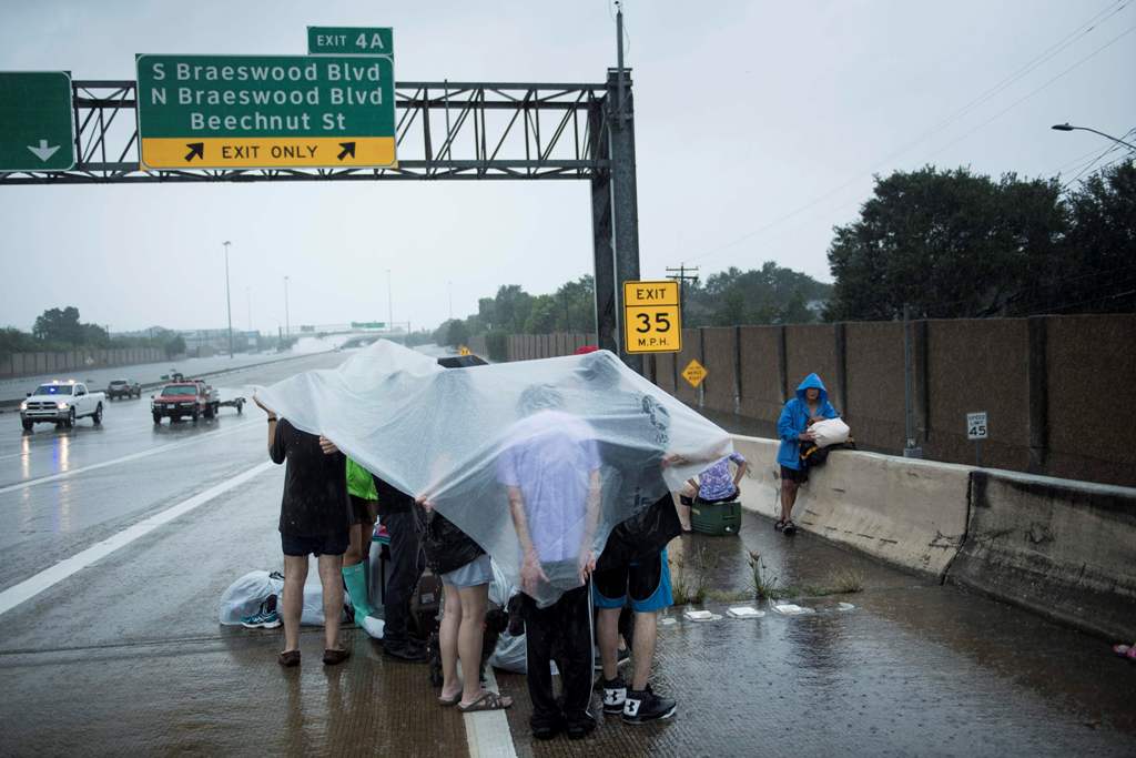 Evacuation residents from the Meyerland wait on an I-610 overpass for further help during the aftermath of Hurricane Harvey August 27, 2017 in Houston, Texas. AFP / Brendan Smialowski
