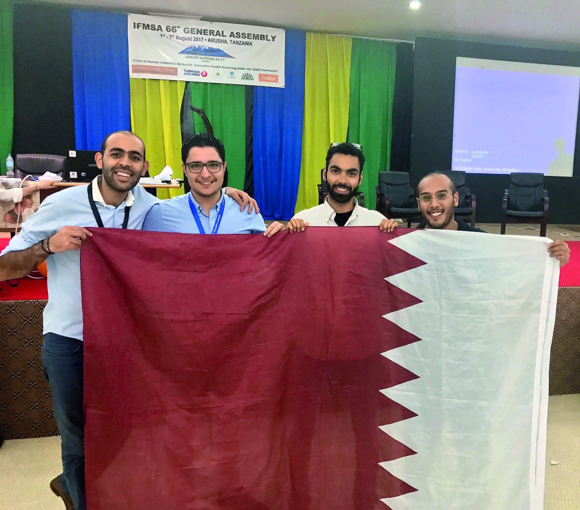 Students pose for a picture with Qatar’s flag. 