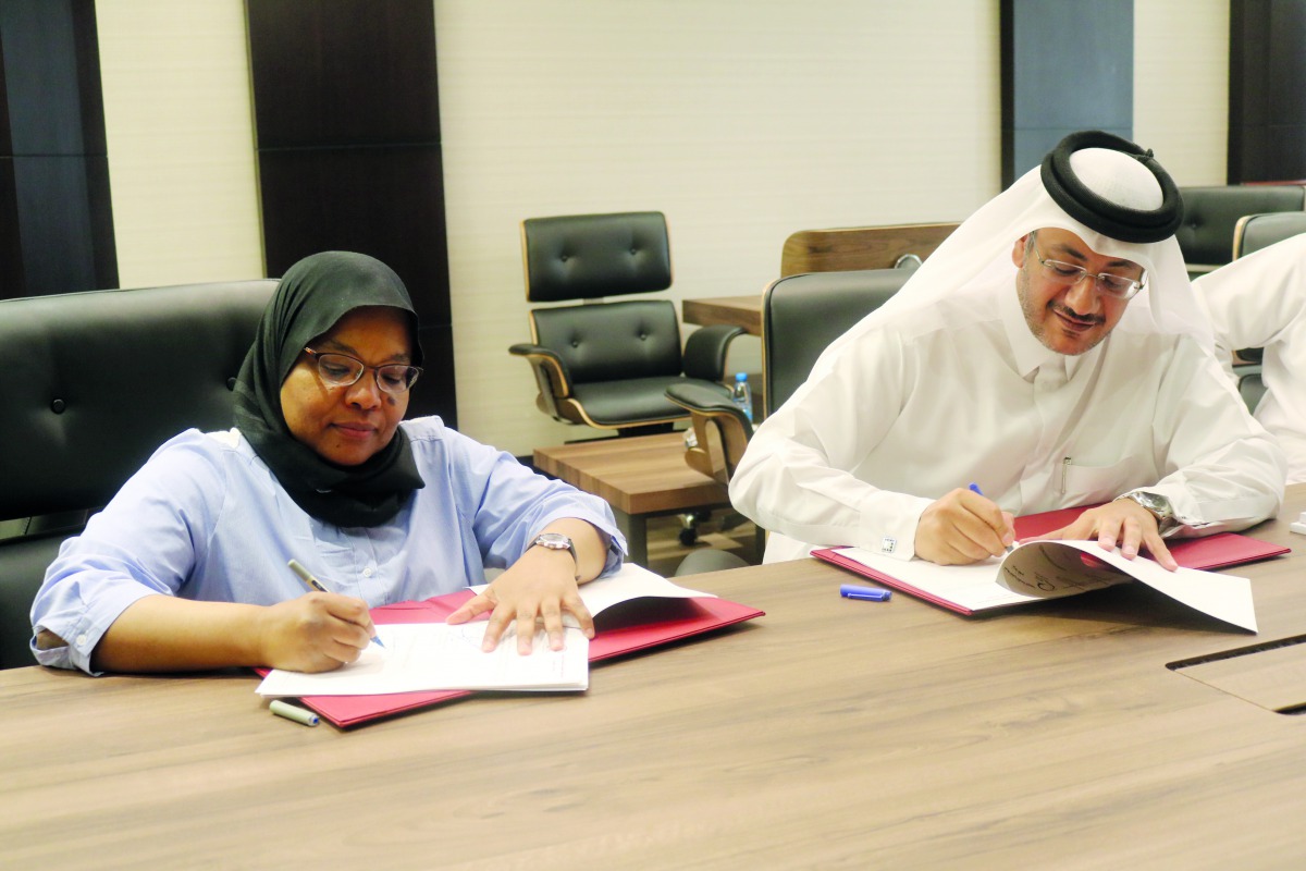 Faleh Mohammed Al Naemi (right), Chairman and CEO of Qatar Post, and Howaida Nadim, CEO of Foresight Communications, the owner of PurpleBox platform, sign the agreement at Qatar Posts headquarters yesterday. 
